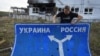 RUSSIA – Ukrainian historian Yuri Savchuk, head of the Kyiv-based Ukrainian WWII history museum, carries a road sign in Sudzha, Kursk region, Russia, August 16, 2024 