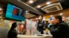 People watch a TV broadcasting the news of Russian troops launching their attack on Ukraine at a restaurant in Hong Kong on February 24.