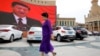 An ethnic Uyghur woman walks in front of a giant screen showing Chinese President Xi Jinping in the main square in the city of Kashgar in the Xinjiang Uyghur Autonomous Region. (file photo)