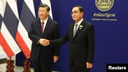 Chinese President Xi Jinping (left) meets with Thai Prime Minister Prayuth Chan-ocha on the sidelines of the Asia-Pacific Economic Cooperation summit in Bangkok on November 19.