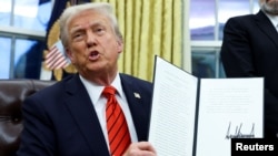 U.S. President Donald Trump holds a signed executive order on tariffs on aluminum imports in the Oval Office of the White House in Washington on February 10.