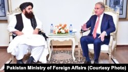 Taliban Foreign Minister Amir Khan Muttaqi (left) meets with his Pakistani counterpart, Shah Mahmood Qureshi, in Islamabad on December 18.