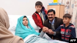 Pakistani schoolgirl Malala Yousafzai (center) recovering in a U.K. hospital with her mother, Thorpekai (left), brothers Khushal Khan (third right) and Apal Khan (far-right), and her father, Ziauddian. 