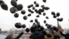 Russian opposition activists and human rights defenders release black balloons in front of the Kremlin to mark the sixth anniversary of the death in prison of lawyer Sergei Magnitsky in Moscow on November 16, 2015.