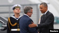 U.S. President Barack Obama (right) is greeted by Polish President Bronislaw Komorowski upon his arrival in Warsaw this morning.