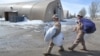 U.S. servicemen carry bags as they dismantle a tent camp at the U.S. transit center at Manas on March 6.