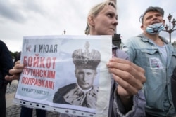 A woman holds a poster reading "July 1. Boycott Of Putin's Amendments!" during a protest in St. Petersburg on July 1.