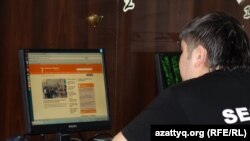 Интернет клубта Азаттық веб сайтын оқып отырған жігіт. Көрнекі сурет