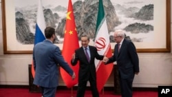 Chinese Foreign Minister Wang Yi welcomes Russian Deputy Foreign Minister Sergei Ryabkov (right) and Iranian Deputy Foreign Minister Kazem Gharibabadi (left) in Beijing, March 14