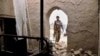 An Afghan security official inspects the scene of a suicide bomb attack on December 7 in Kandahar, where government forces and the Taliban have clashed regularly since October.