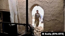 An Afghan security official inspects the scene of a suicide bomb attack on December 7 in Kandahar, where government forces and the Taliban have clashed regularly since October.