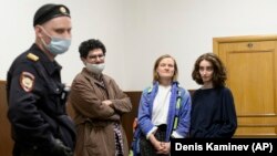 Three of the four former editors of Doxa sentenced to two years of correctional labor in December 2022 wait for a court session in Moscow in April 2021.