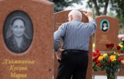 A man mourns at the cemetery where victims of the 2004 school siege are buried on the 15th anniversary of the siege in the southern Russian town of Beslan on September 2, 2019.