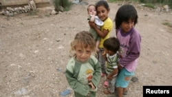 Syrian refugee children, who fled the violence, stand on a road at a northern Lebanese border village 