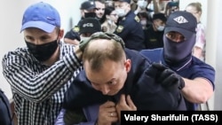 Former Russia journalist Ivan Safronov is escorted to a hearing at a Moscow court on "treason" charges earlier this week. 