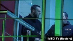 Jack Shepherd is escorted inside a police station in Tbilisi on January 23.