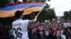 A demonstrator waves an Armenian flag as others shout slogans during a protest against an increase of electricity prices in Yerevan on June 25.