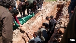 Syrians dig a grave to bury the bodies of victims of a suspected toxic-gas attack in Khan Sheikhun in April 2017.