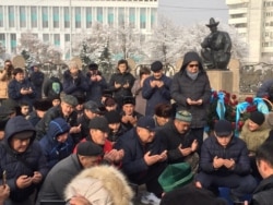 Тәуелсіздік ескерткіші алдында құран оқып отырған адамдар. Алматы, 16 желтоқсан 2019 жыл.