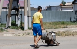 Қоларбамен ауызсу тасып жүрген жігіт. Қызылсуат ауылы, Ақмола облысы. 10 маусым 2020 жыл.