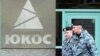 Two Russian policemen pass by the Yukos oil giant's logo during the controversial auctioning of some of the company's key assets at its headquarters in 2007. (file photo)