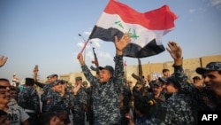 Iraqi federal police dance with civilians and an Iraqi flag to celebrate success against Islamic State fighters in Mosul on July 2, 2017.