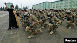 A priest blesses Georgian soldiers during a farewell ceremony at the Vaziani military base outside Tbilisi in December, before the troops' departure to Afghanistan.