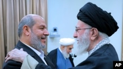 Iranian Supreme Leader Ayatollah Ali Khamenei (right) greets Hama leader Khalil al-Hayya in Tehran on February 8. 