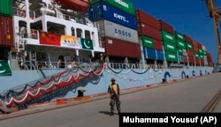 A security guard stands outside a ship at the port of Gwadar, which has been leased to a Chinese corporation by the Pakistani government.