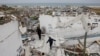 Youths walk amid the ruins of Gaza City during the current cease-fire.