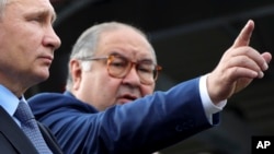 Russian tycoon Alisher Usmanov (right) with Russian President Vladimir Putin (file photo)